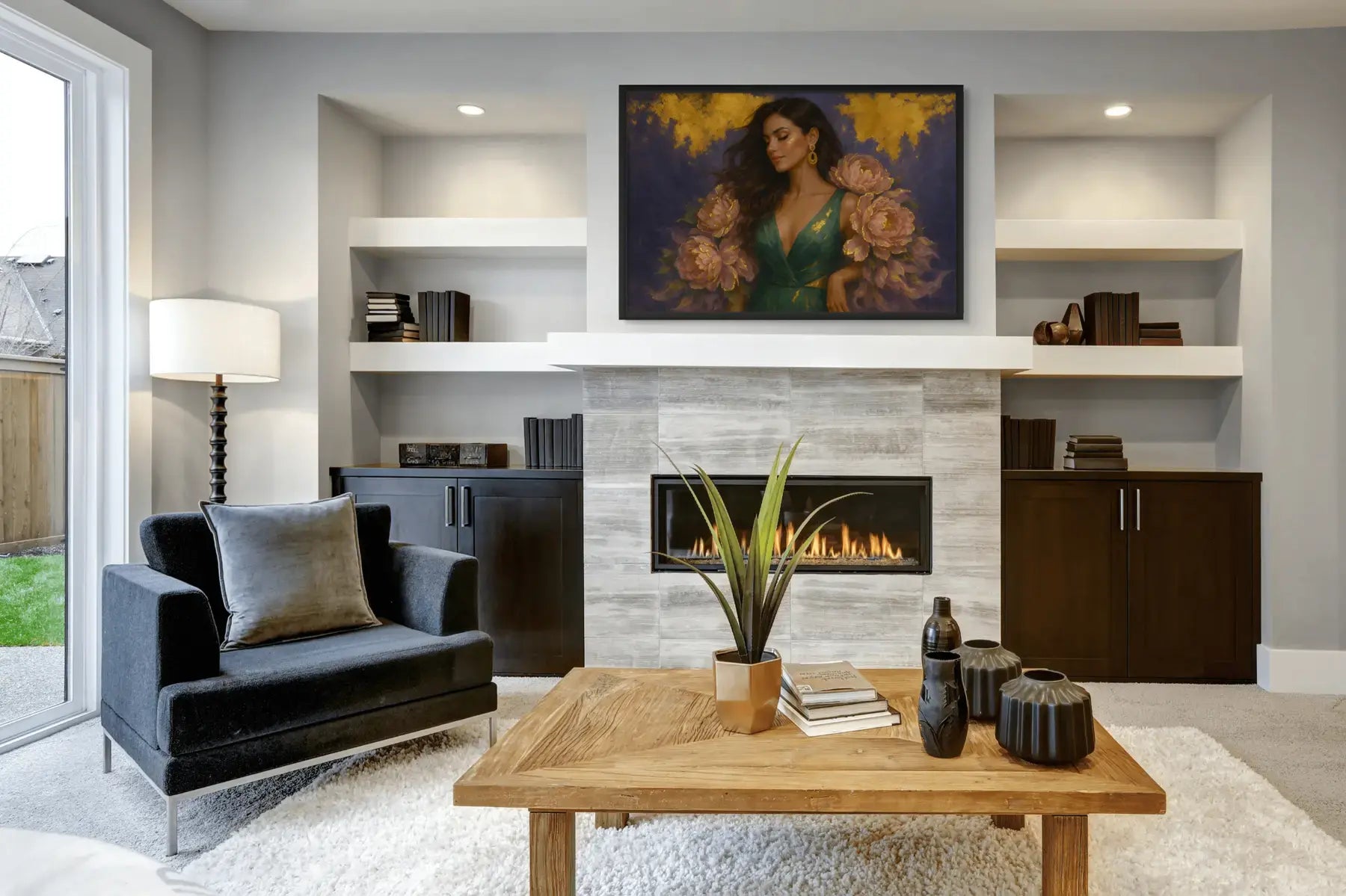 Luxury gold leaf portrait painting featuring a refined woman in an emerald gown with peony florals, displayed in a black frame above a fireplace in a modern living room setting.