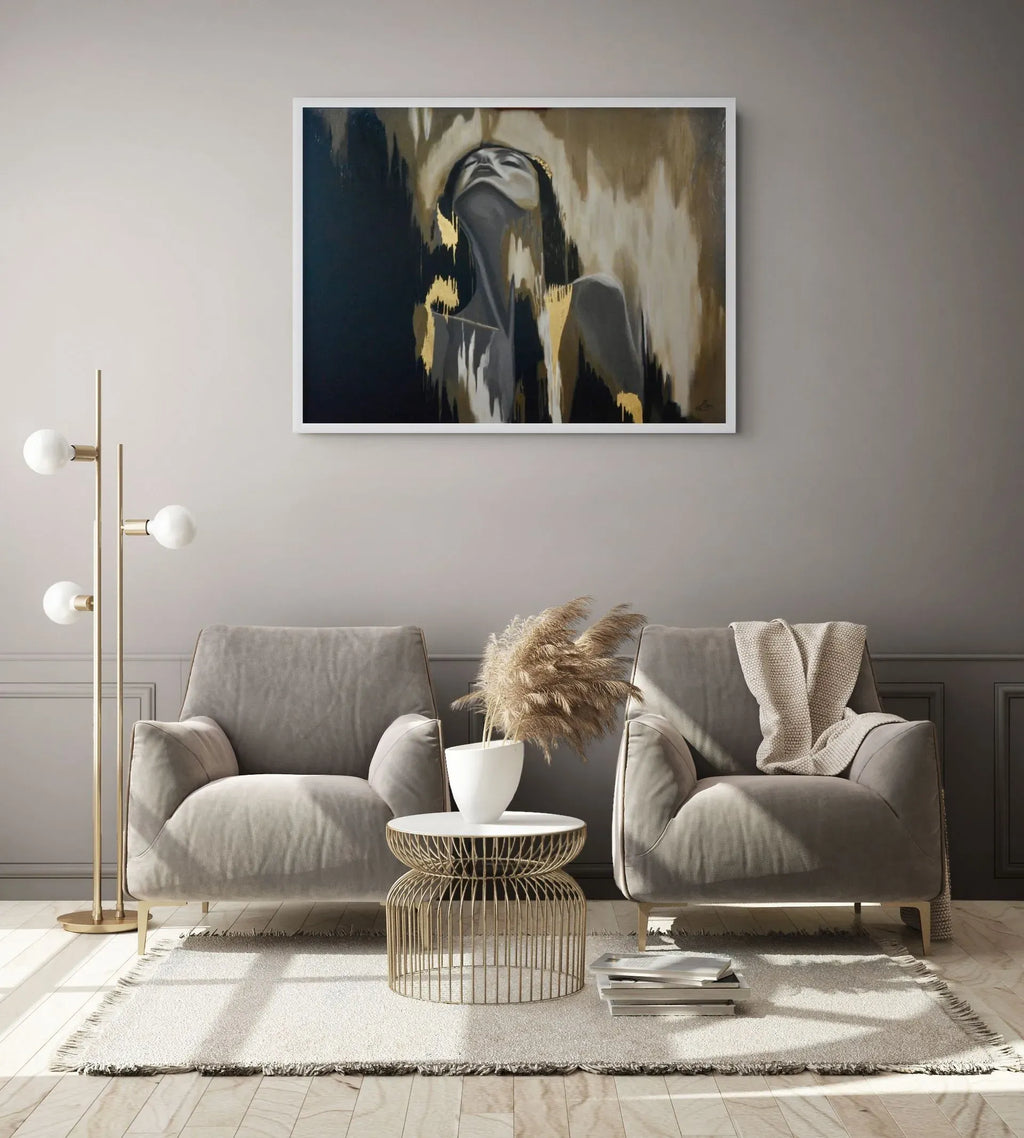 Release mixed media figurative painting with 23K gold leaf displayed in a sophisticated neutral living room hanging above a graey sofa in a modern living room. The artwork features a stylised portrait with black, beige, grey, and gold brushstrokes.