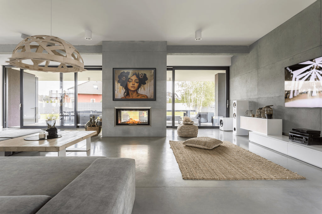 Modern living room with grey walls, a fireplace, and a large window featuring Golden Veil couture portrait with gold leaf foiling.